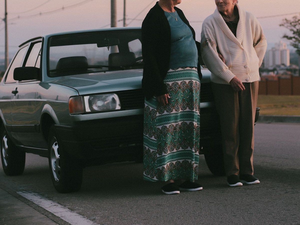 Duas senhoras ao lado de um carro na rua