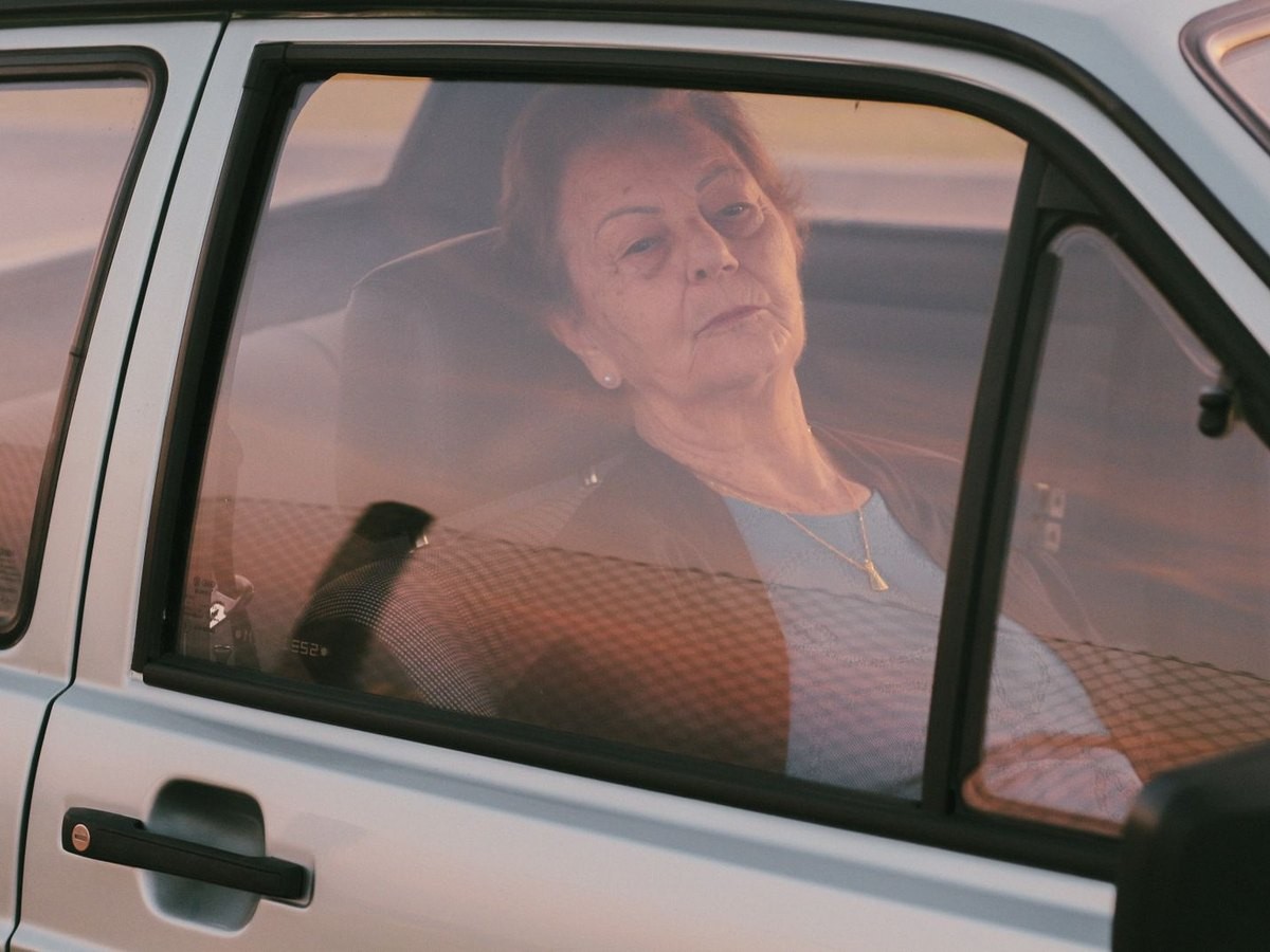 Idosa no banco de trás de um carro